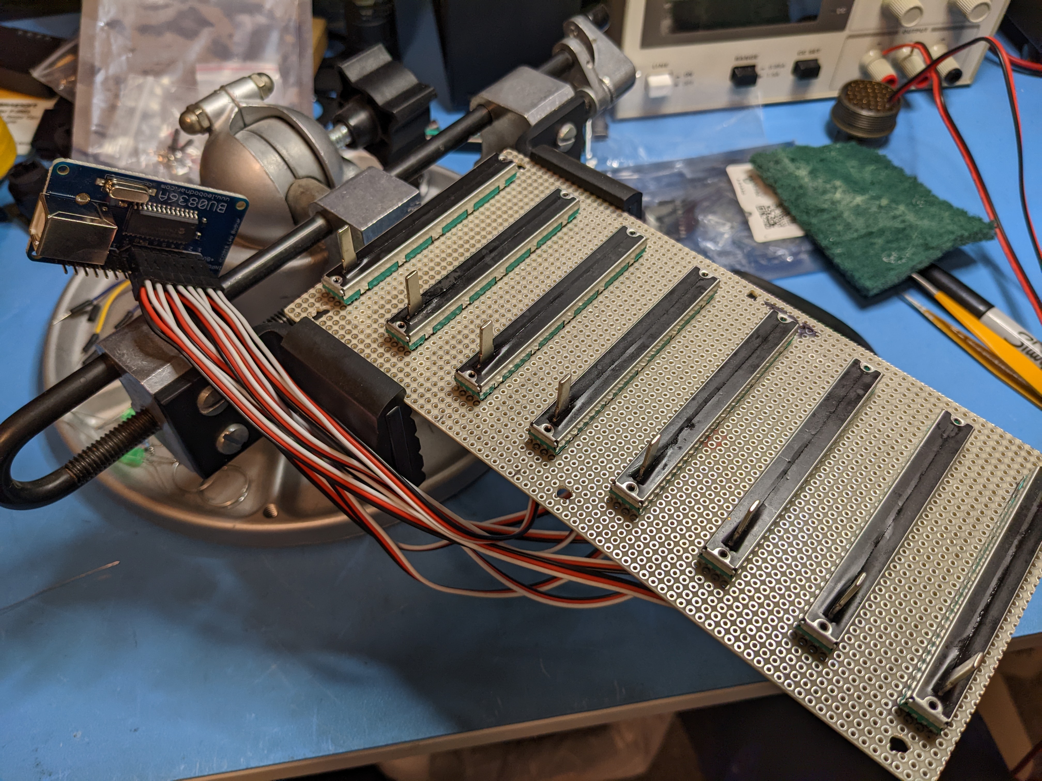 Photo of eight slide potentiometers mounted on perfboard
