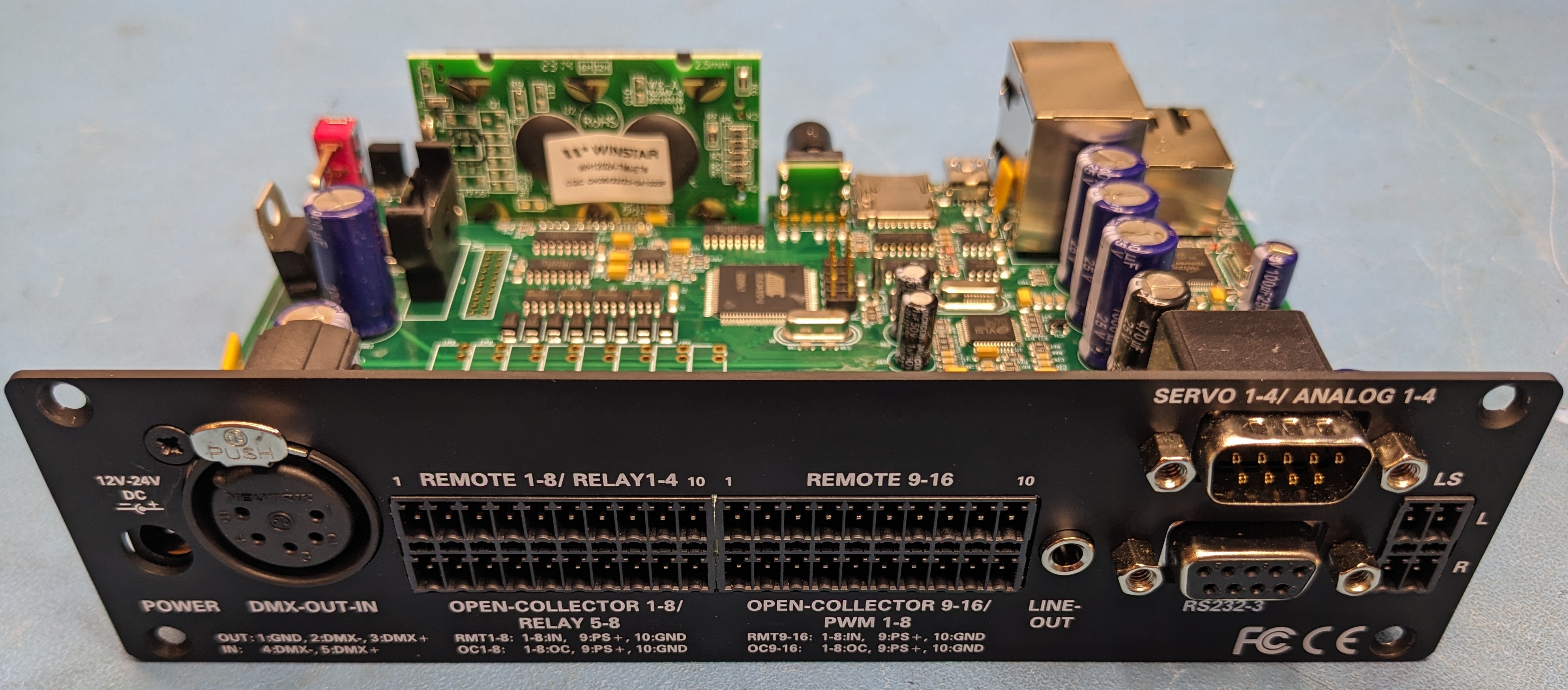 Weigl ProCommander4 rear panel with lid removed, showing RS-232, RS-485, DMX, servo, analog, digital I/O, and audio connectors